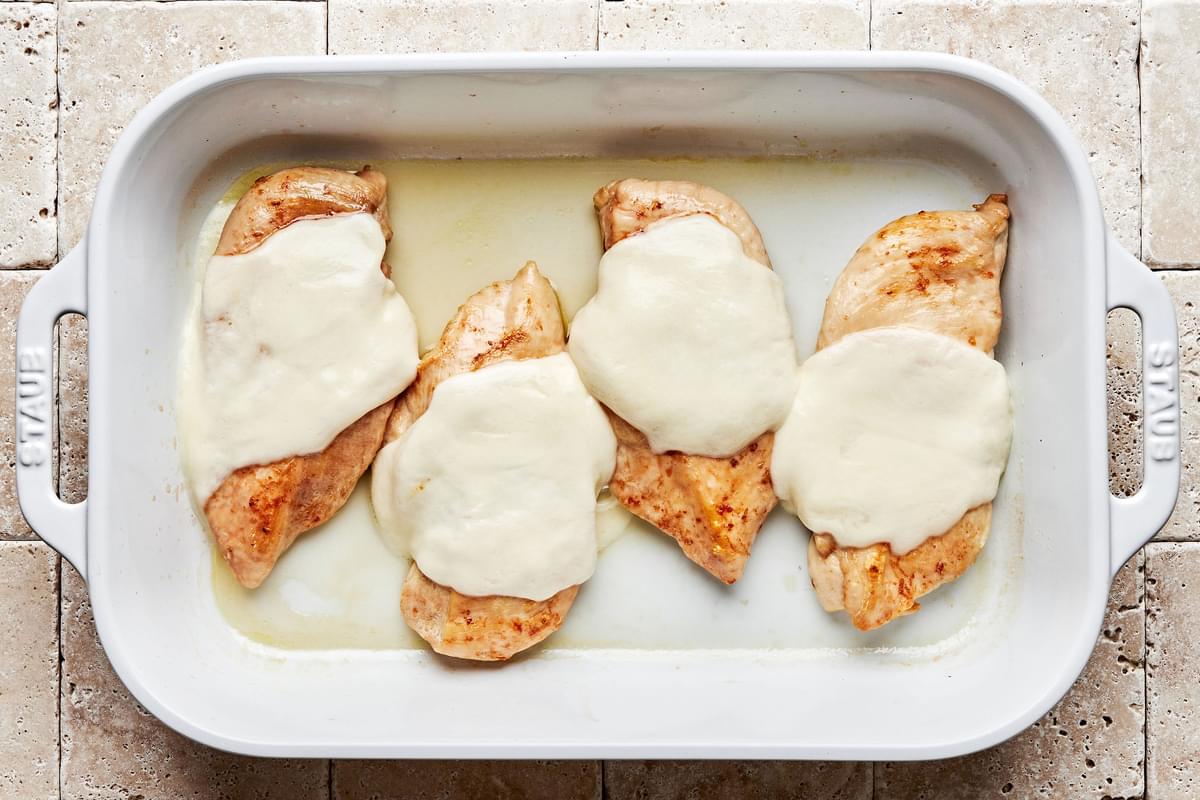 baked chicken with melted mozzarella on top in a casserole dish