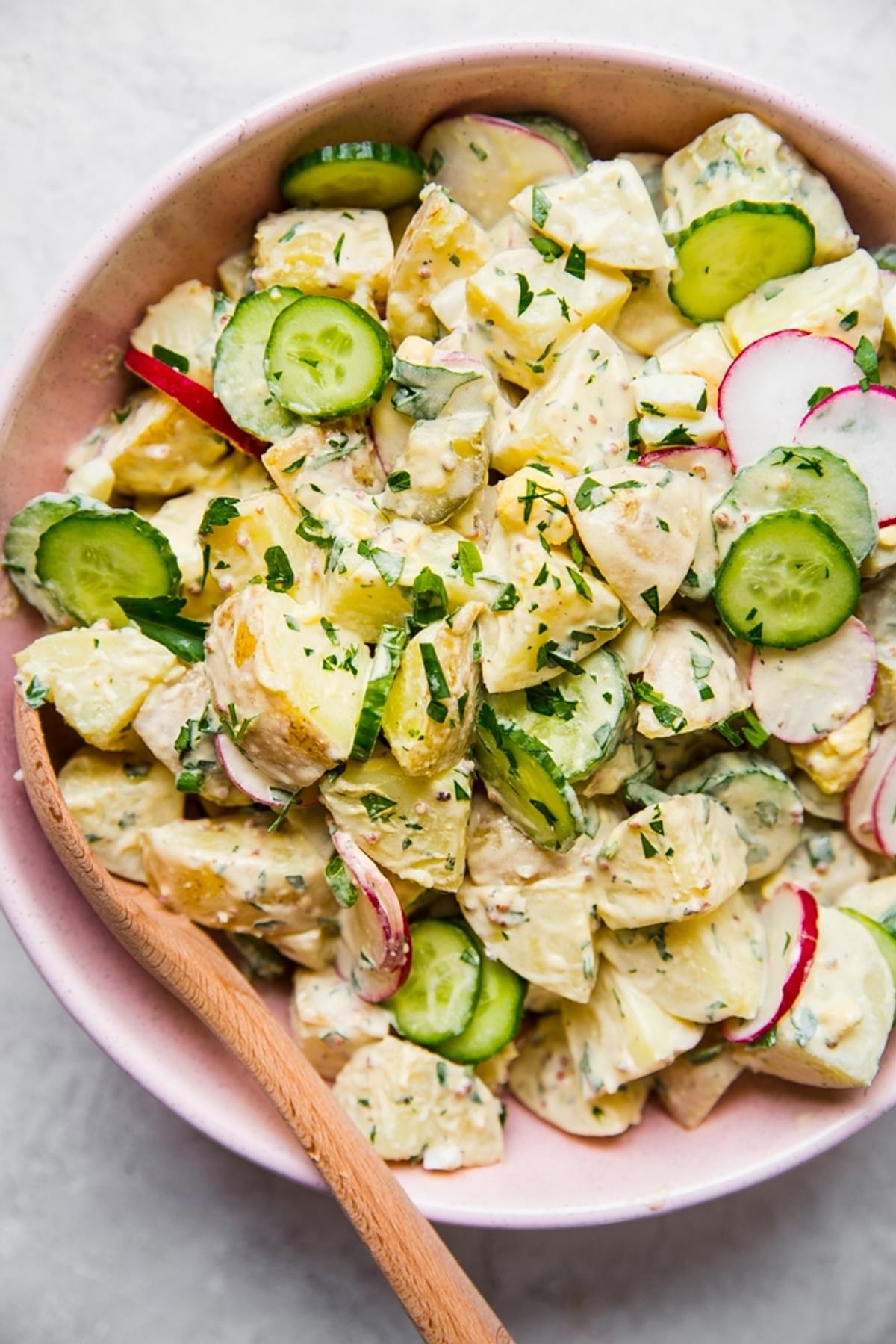 Easy potato salad in a bpwl with a wooden spoon