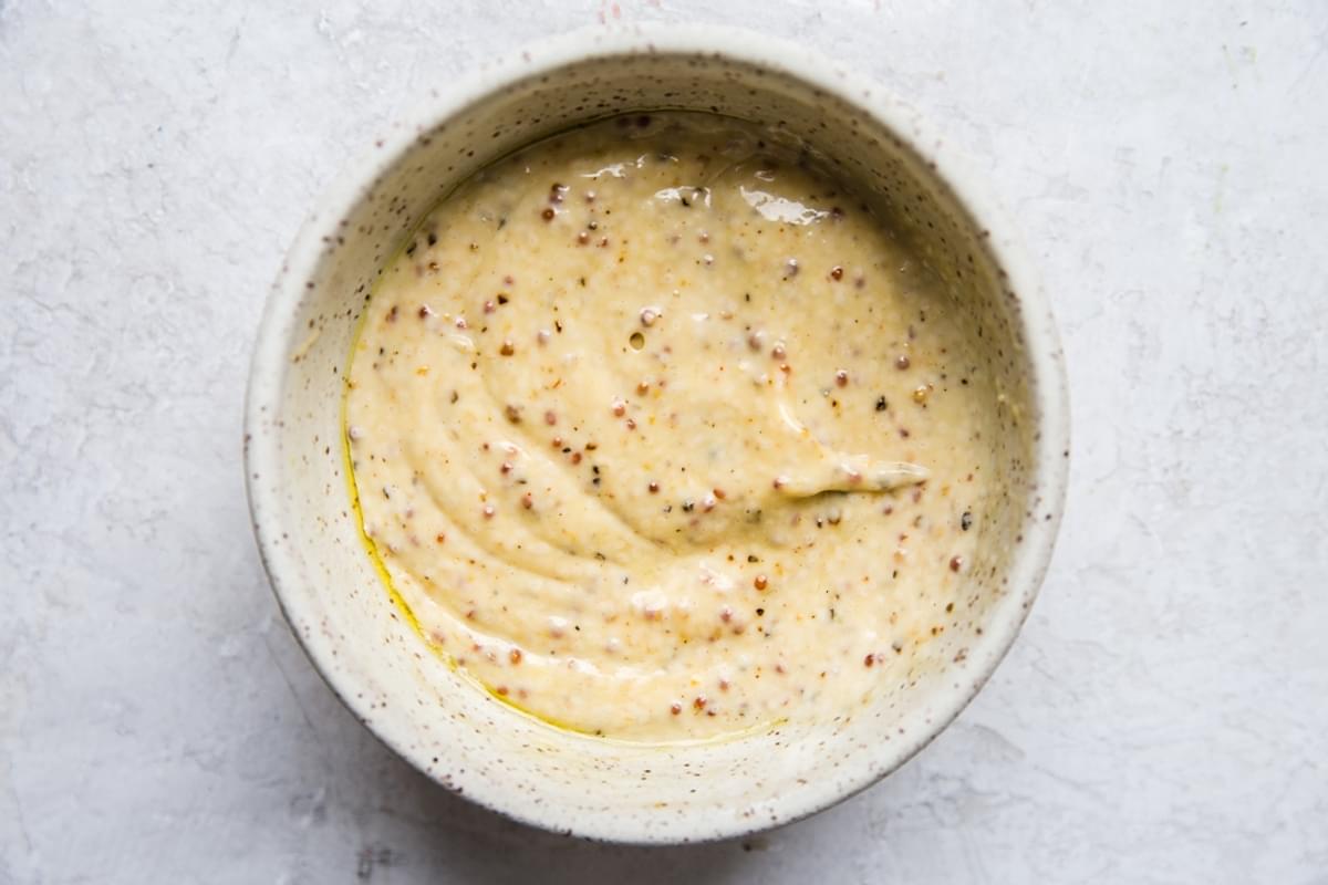 mustard, salt pepper mayonnaise and pickle juice mixed up in a bowl for potato salad dressing
