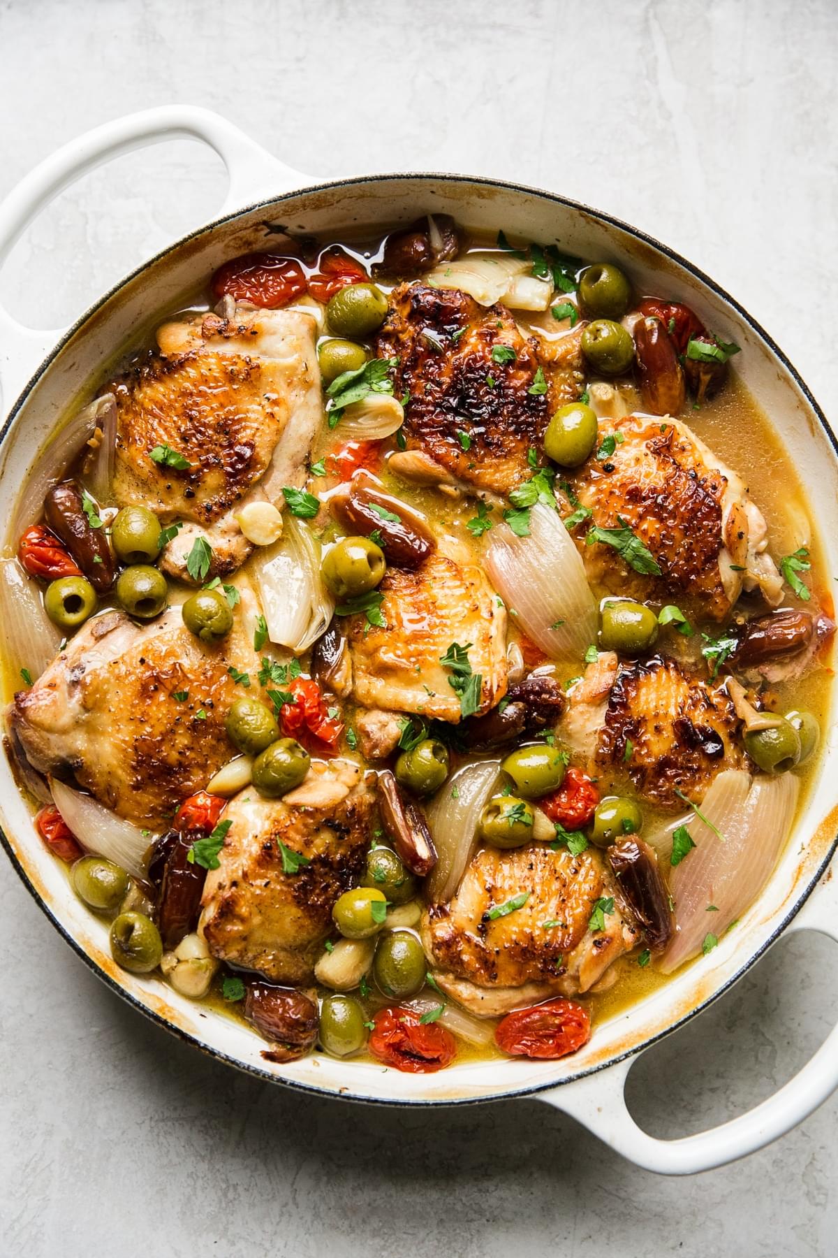 Chicken Provençal with olives, tomatoes, shallots, and white wine and thyme in a large braising pot