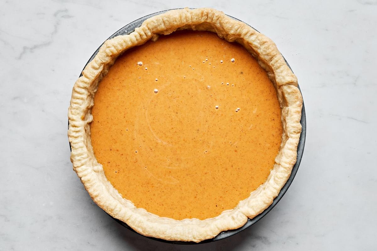 a par-baked pie crust filled with pumpkin pie filling