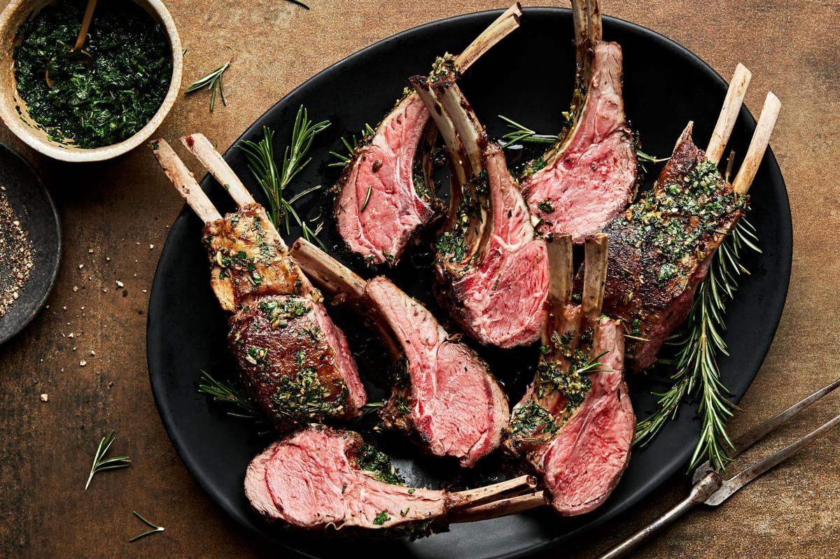 rack of lamb, sliced topped with mint sauce on a serving platter