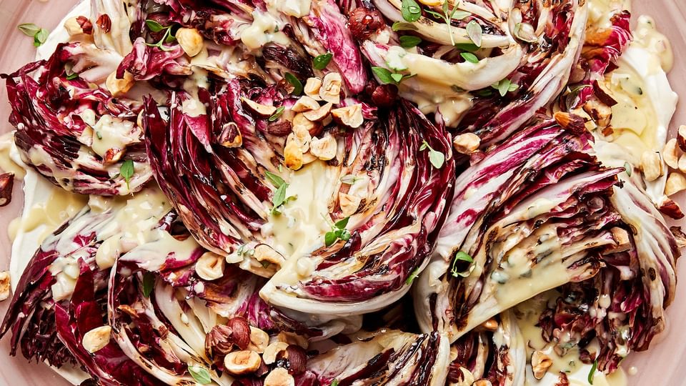 Radicchio salad with Crème Fraîche Vinaigrette sprinkled with toasted hazelnuts, thyme and drizzled with honey on a plate