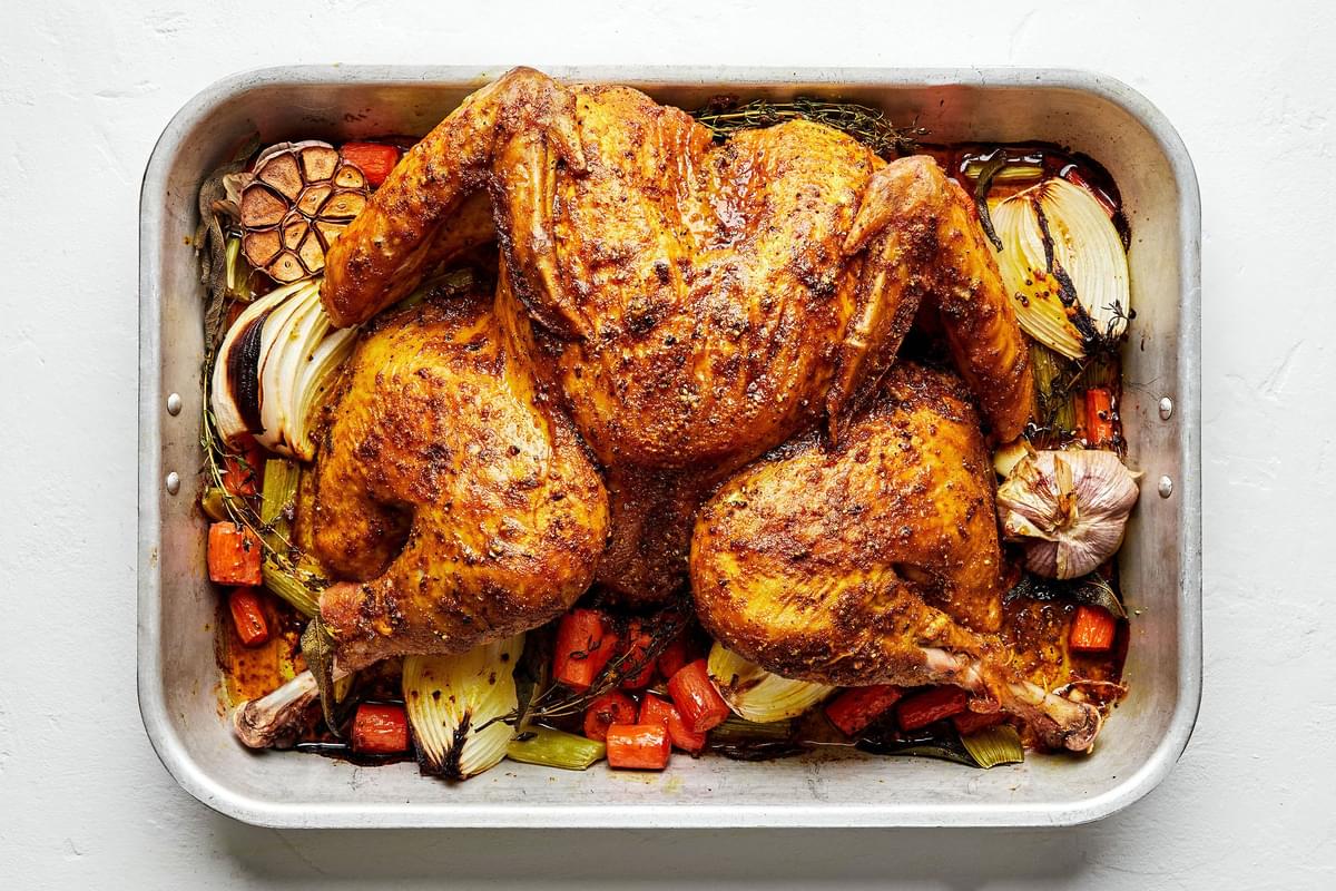 A Roast Spatchcocked Turkey seasoned with sage, thyme, turmeric, garlic, pepper and paprika in a roasting pan