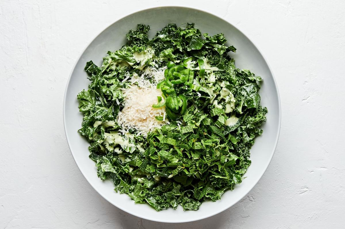 kale tossed with serrano mint salad dressing topped with parmesan, serrano peppers and mint leaves