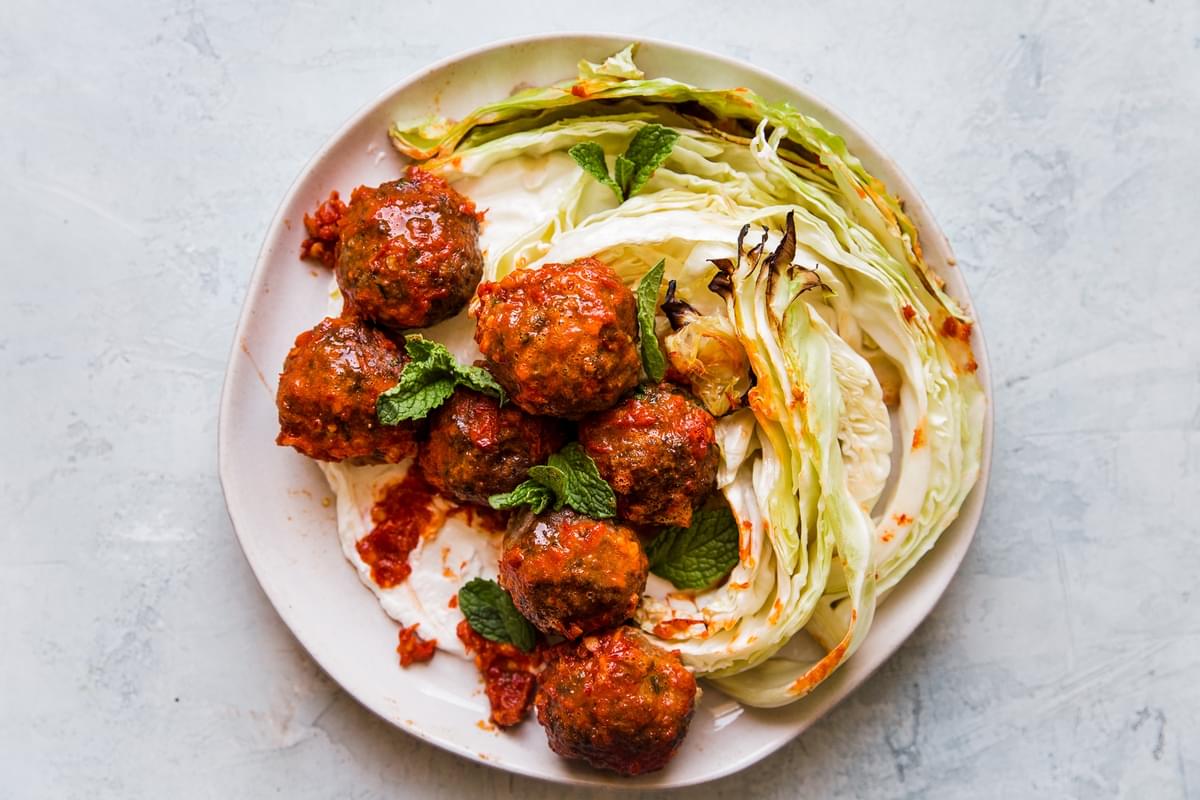 Sheet pan Meatballs with Cabbage and Harissa on a plate