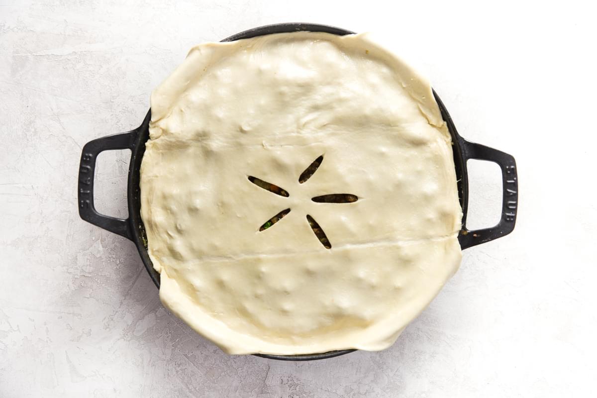 a large skillet with puff pastry over a lamb pot pie