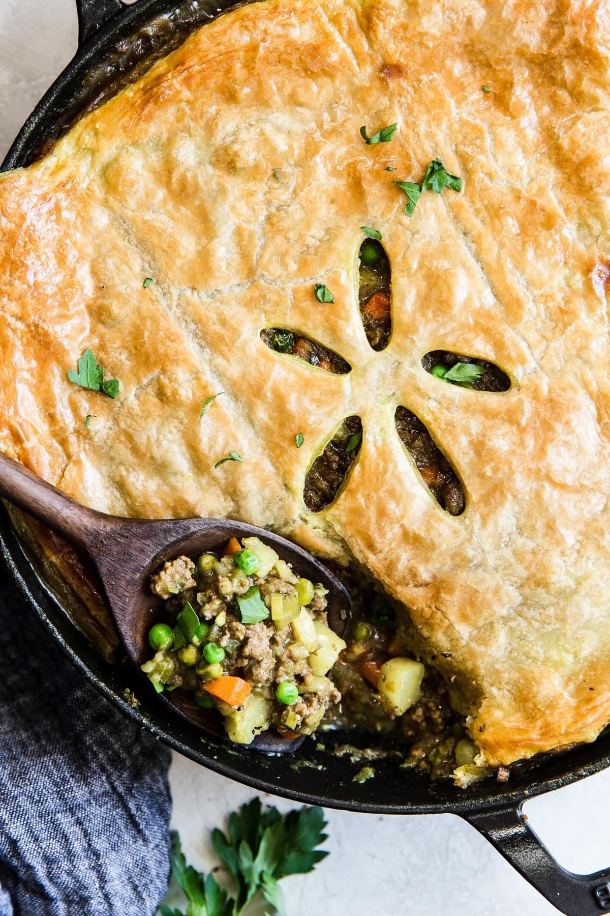 ground Lamb Pot Pie with Curry, potatoes, carrots and peas in a cast iron skillet