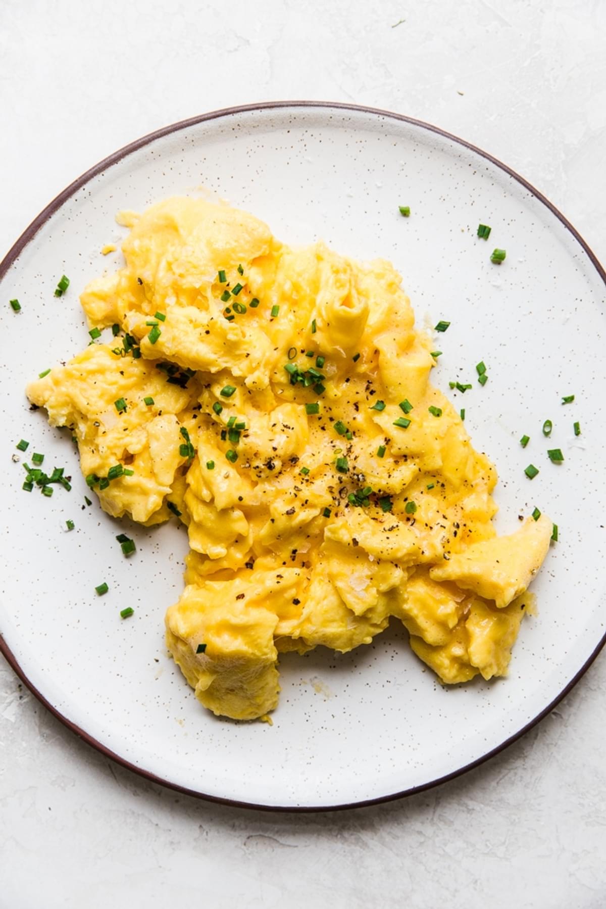 soft scrambled eggs on a plate with chives