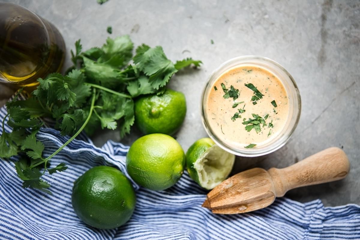 Chipotle dressing in a jar with cilantro, olive oil and limes