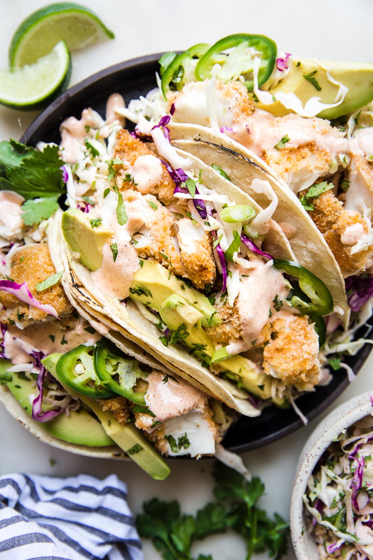 cajun crispy fish tacos with jalapeño and avocado in a plate