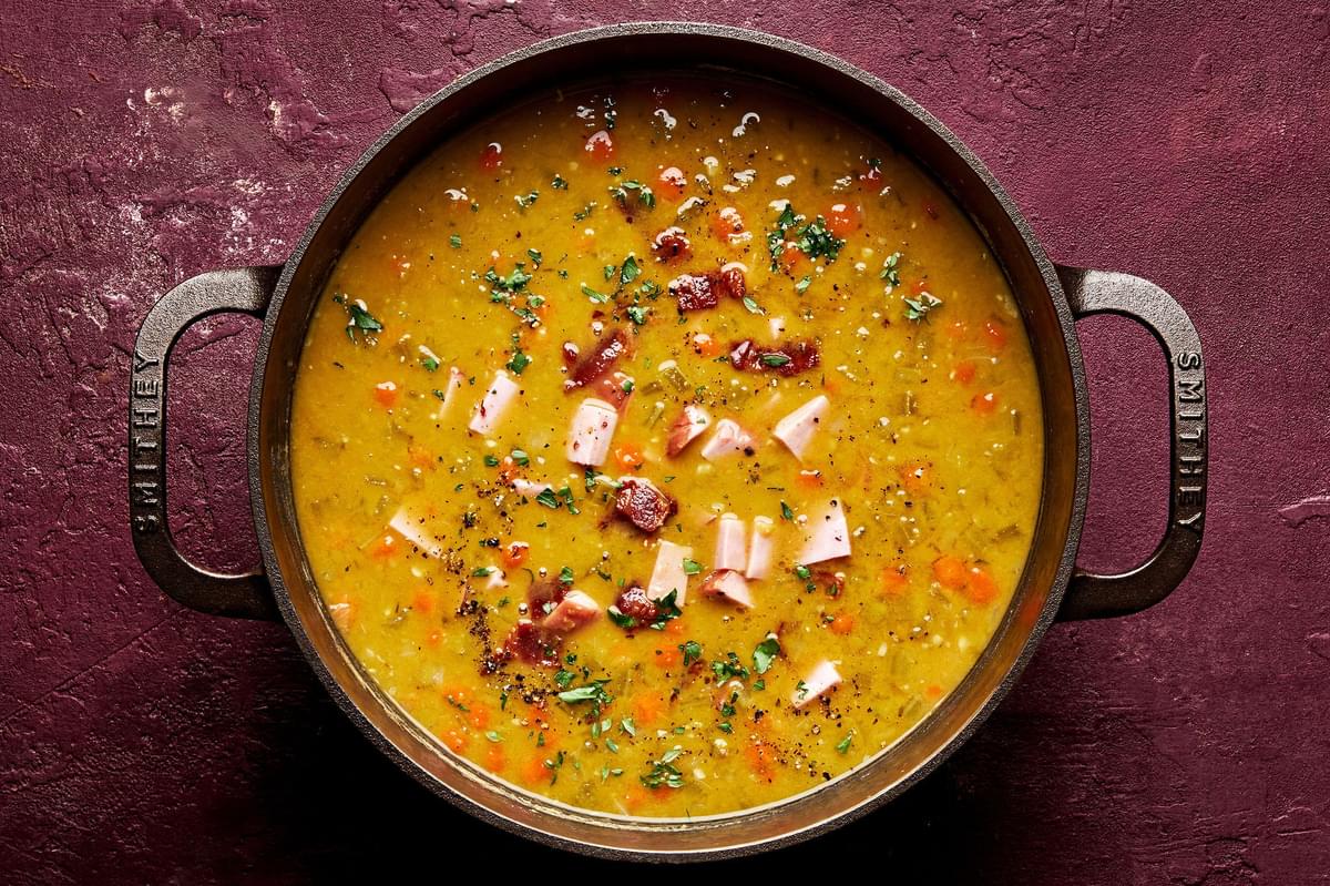 a pot of homemade split pea soup with ham, bacon, celery, carrots, onion, chicken stock and spices
