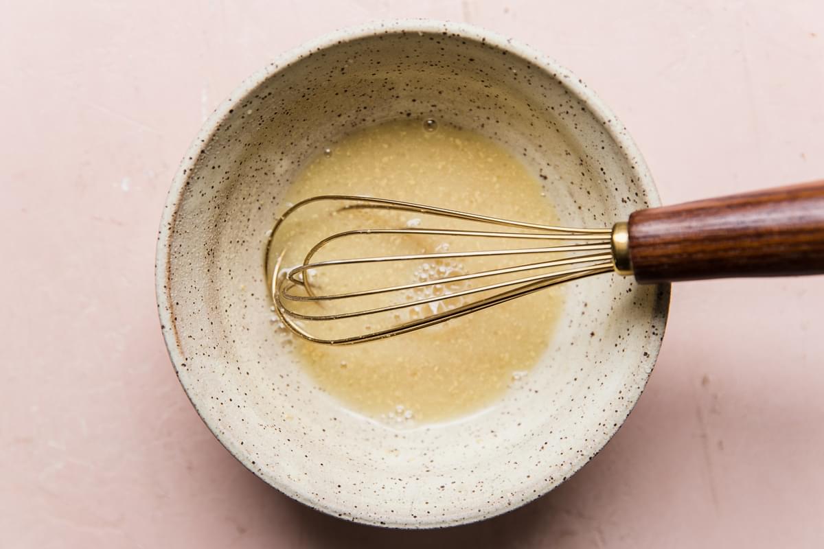 lemon chive vinaigrette in a bowl with a whisk