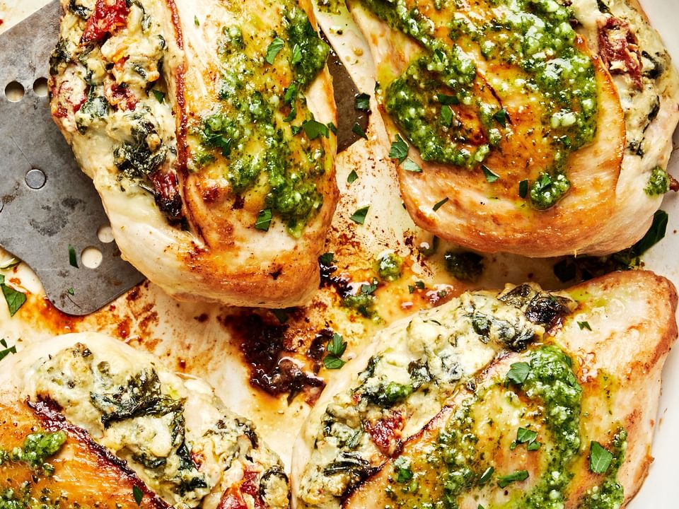 4 chicken breasts stuffed with spinach, garlic, cream cheese, mozzarella &  sun-dried tomatoes topped with pesto in a skillet