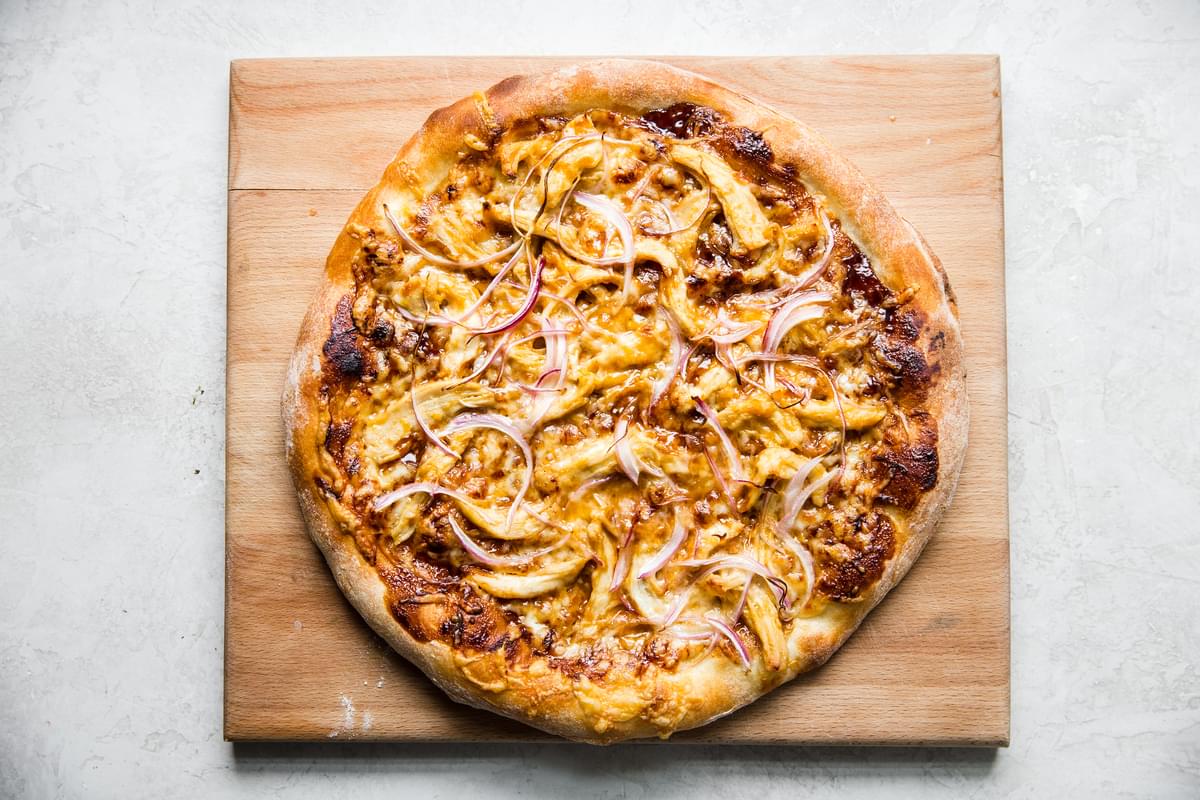 Thai style chicken pizza with cheese. onions, hoisin sauce and peanuts