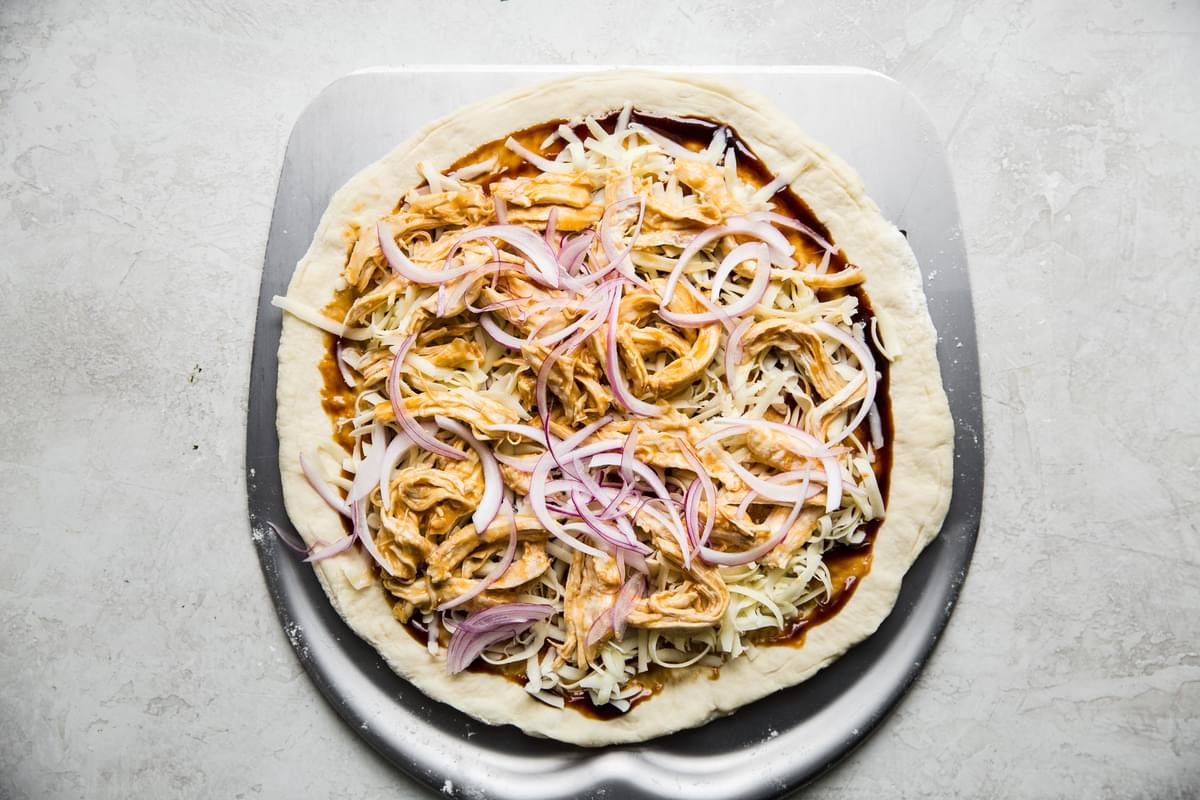 Thai style chicken pizza with cheese. onions, housing sauce and peanuts