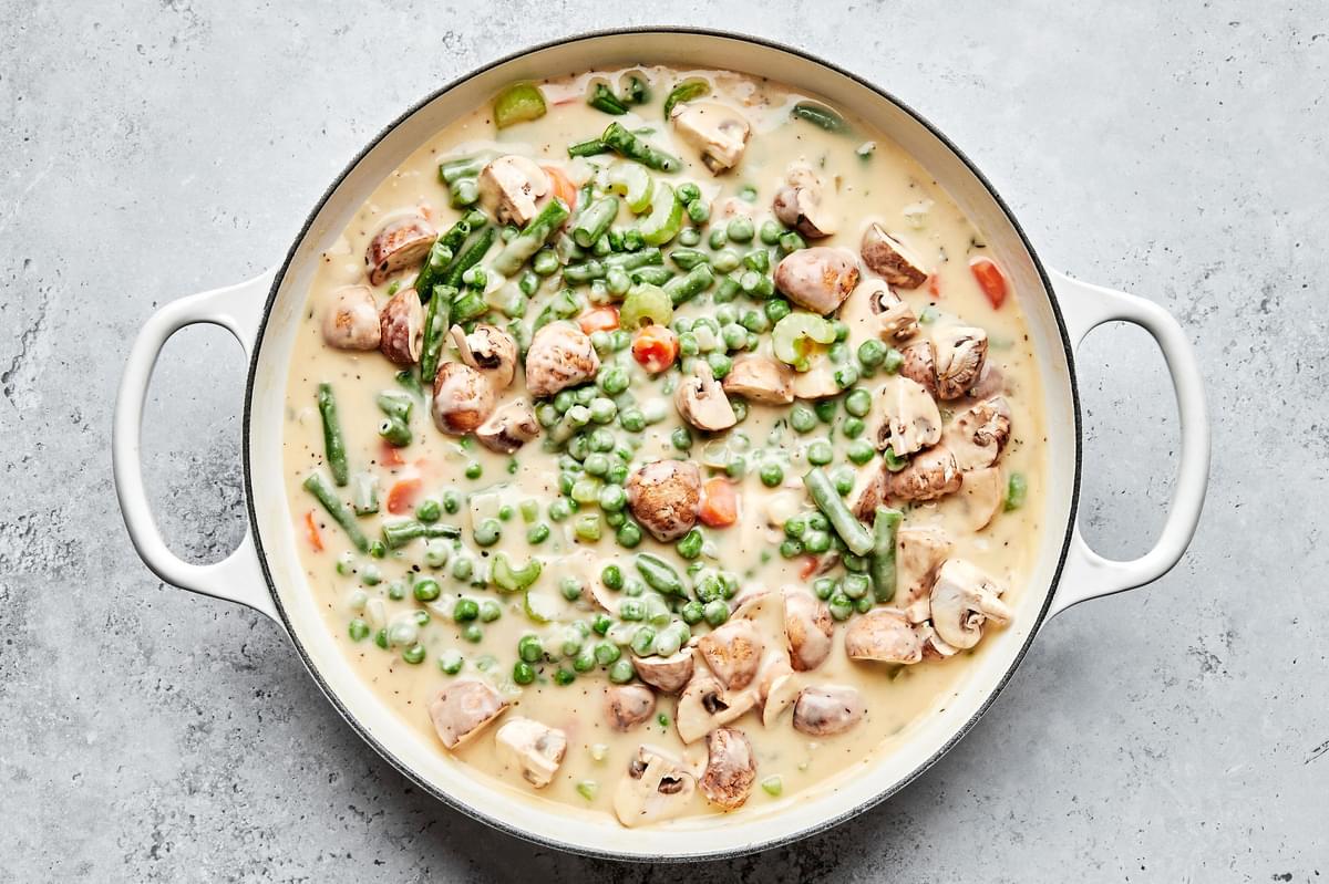 vegetable pot pie filling in a skillet made with peas, mushrooms and green beans