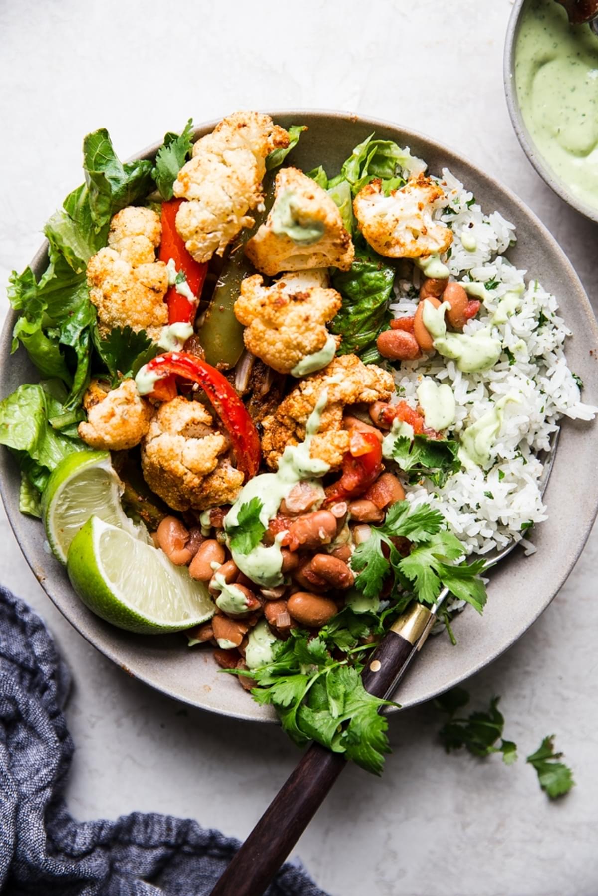 vegetarian burrito bowl with cilantro rice, cauliflower limes and beans