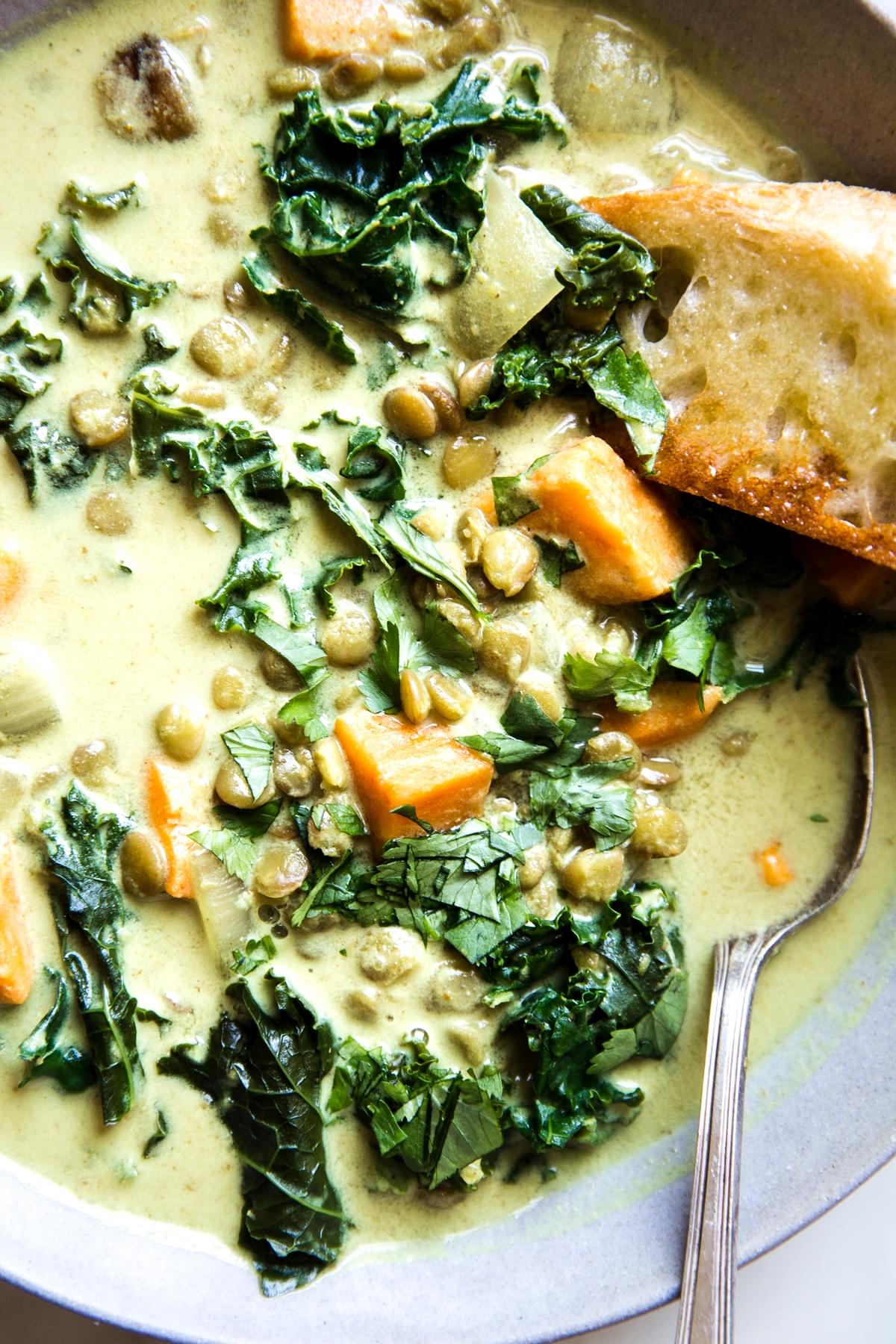 Coconut curry lentil soup with sweet potatoes a kale in a bowl