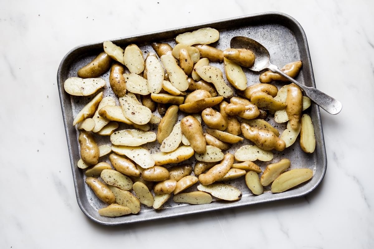 fingerling potatoes on a baking sheet with olive oil, salt and pepper