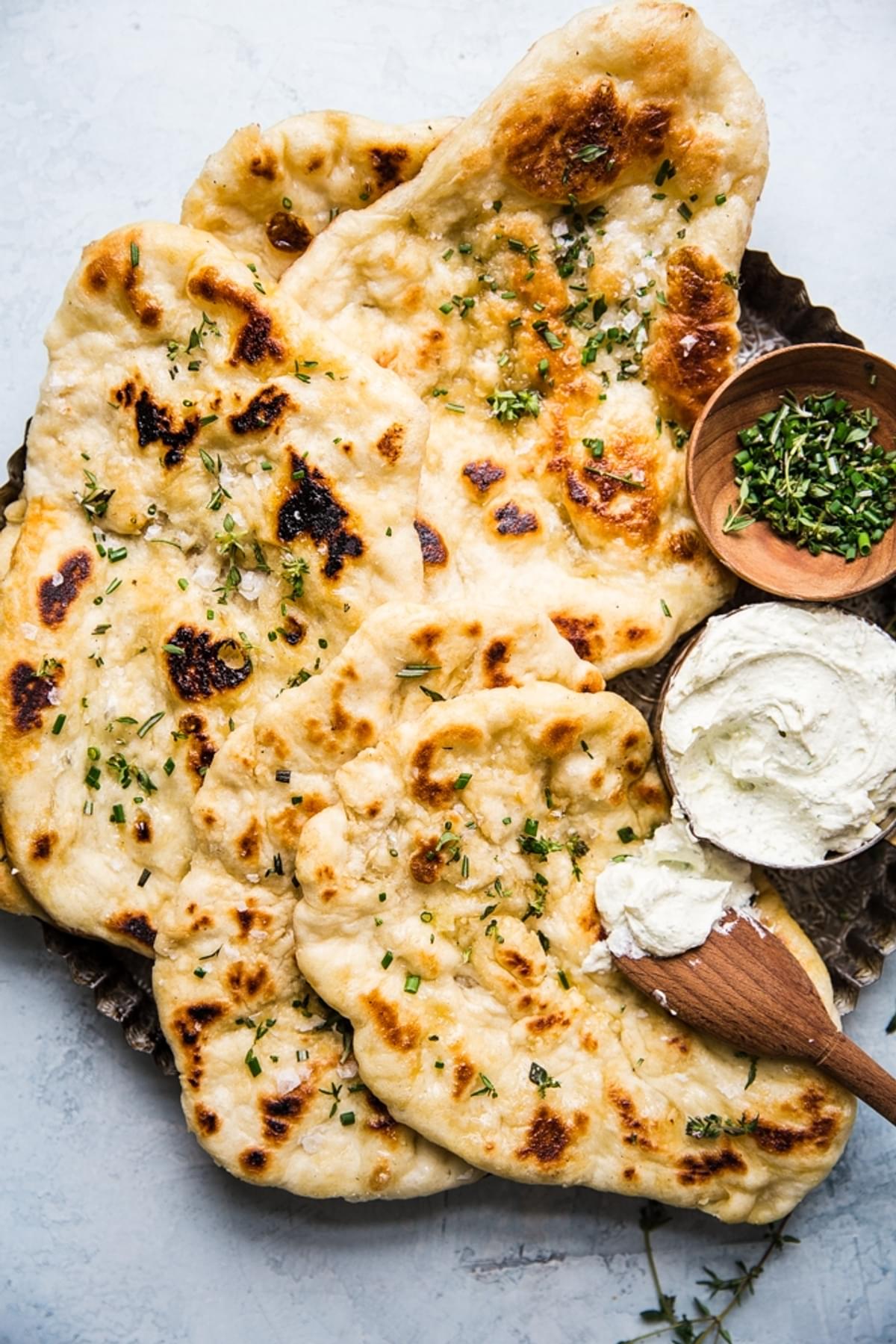 Herbed homemade flat bread with whipped feta cheese spread on a serving plate