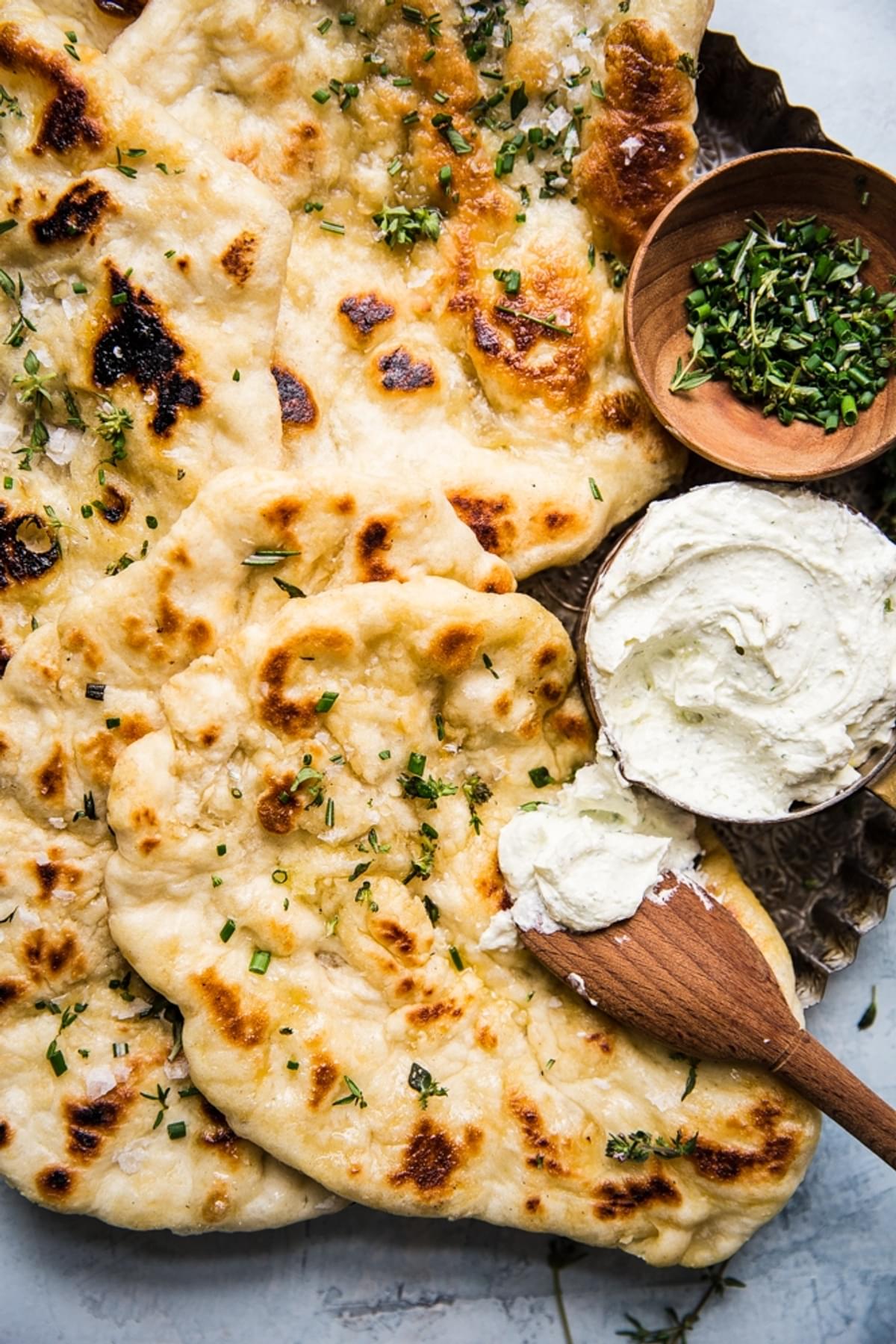 Herbed homemade flat bread with whipped feta cheese spread on a serving plate