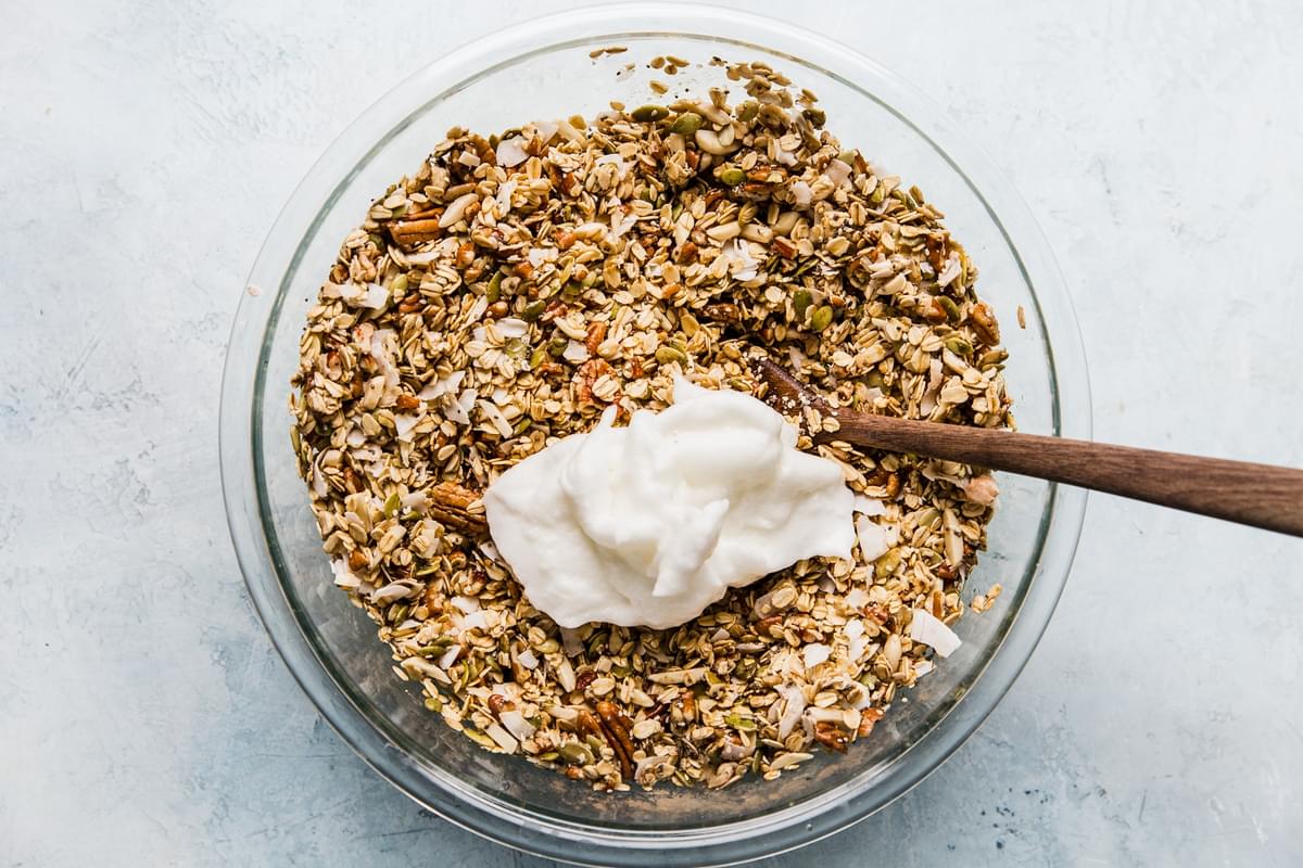 homemade granola being made in a bowl with oats, nuts and seeds