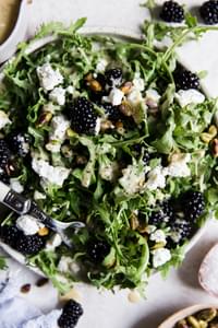 Arugula salad topped with blackberries, chevre, pistachios and a honey mustard salad dressing.