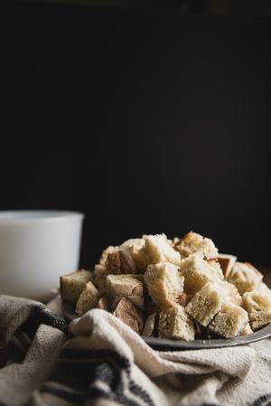 rustic loaf of bread cut up into large cubes on a plate on the table