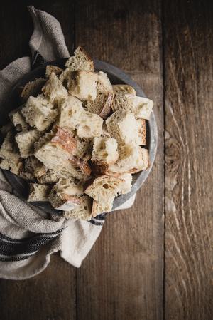 rustic loaf of bread cut up into large pieces on a plate on the table