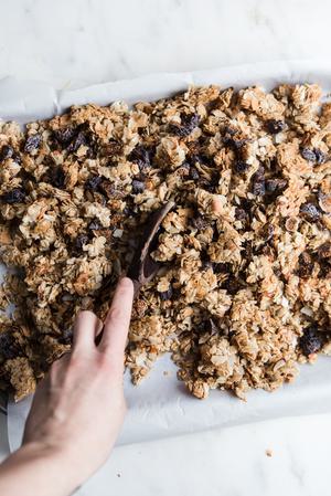 baked homemade Granola with Figs, Almonds and Coconut with a spoon