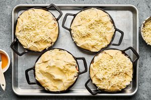 lamb pies made with puff pastry bottom with lamb and veggie filling topped with mashed potatoes, ready to be baked