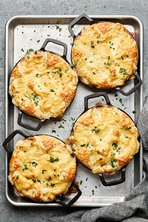 shepherds pies in small ramekins made with a puff pastry bottom, ground lamb and veggies topped with mashed potatoes