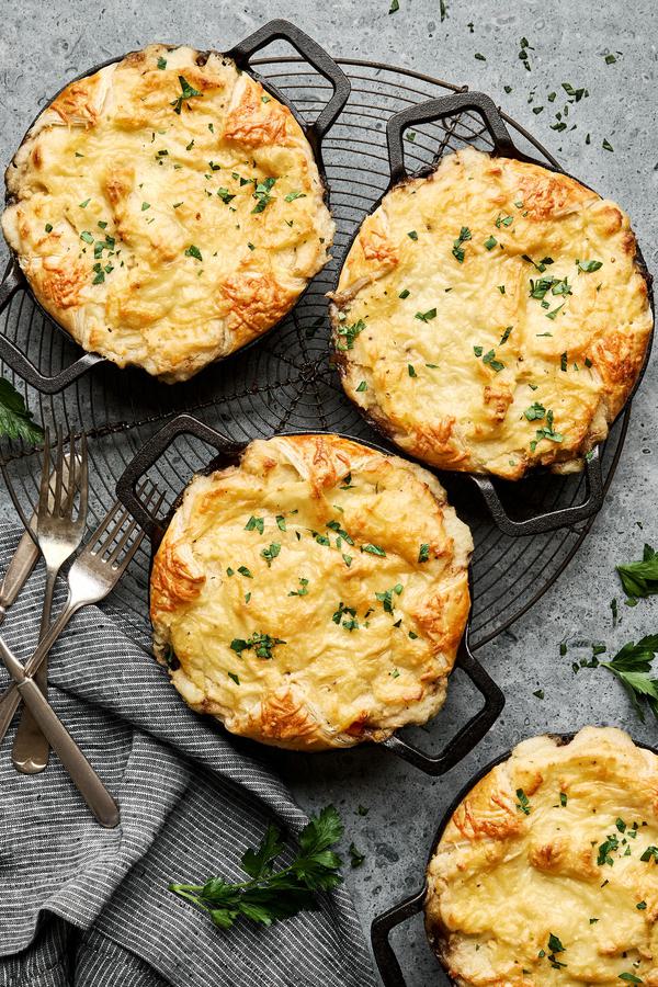 Four individual lamb shepherd’s pies topped with golden mashed potatoes and baked in small ramekins
