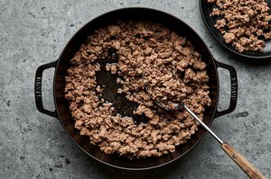 ground lamb cooking in a skillet to be used in a savory meat and vegetable filling for shepherds pie