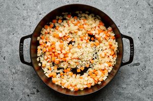veggies cooking in a skillet to make a savory veggie and lamb filling for lamb pie