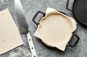 small ramekins being lined with puff pastry to make savory lamb pies, a cozy dinner for cold weather