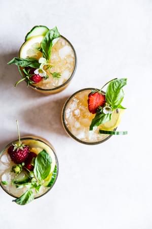 3 Pimm's Cup cocktails with strawberries, cucumber, lemon and basil.