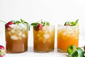 3 Pimm's Cup cocktails with strawberries, cucumber, lemon and basil.