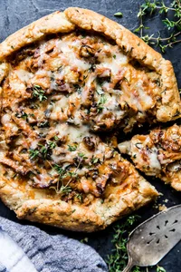 Wild mushroom Galette with herb crust with a slice cut out