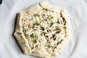 unbaked mushroom galette on parchment paper ready to go in the oven