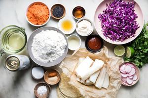 flour, white fish, red cabbage, carrots, oil, sesame oil, cilantro, and corn tortillas