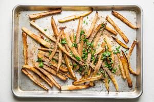 baked French fries on a baking sheet with cilantro