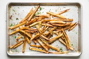 baked French fries on a baking sheet with cilantro