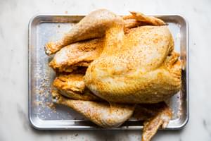 raw dry brined turkey on a baking sheet