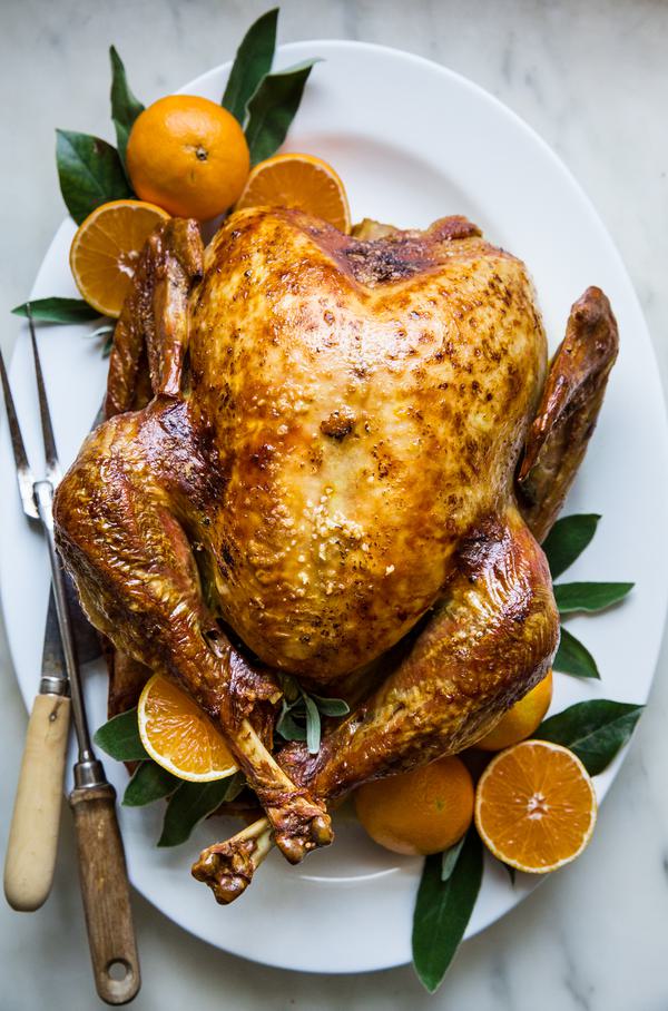 best roast turkey recipe with oranges and sage butter on a serving platter with sage leaves