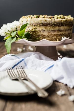 Yogurt and Olive Oil Pistachio Cake With Lemon Buttercream with a plate and 2 forks