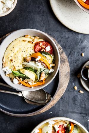 Creamy Goat Cheese Polenta With Ratatouille toasted pine nuts and basil in a bowl