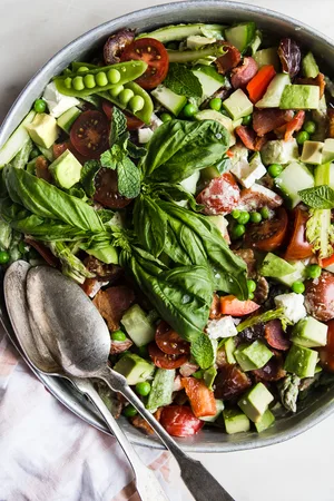 Spring Chopped Salad With Asparagus And Peas on a plate with a serving spoon