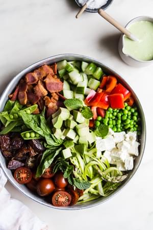 Spring Chop Salad With Asparagus And Peas tomatoes, feta dates and bacon and green goddess yogurt dressing